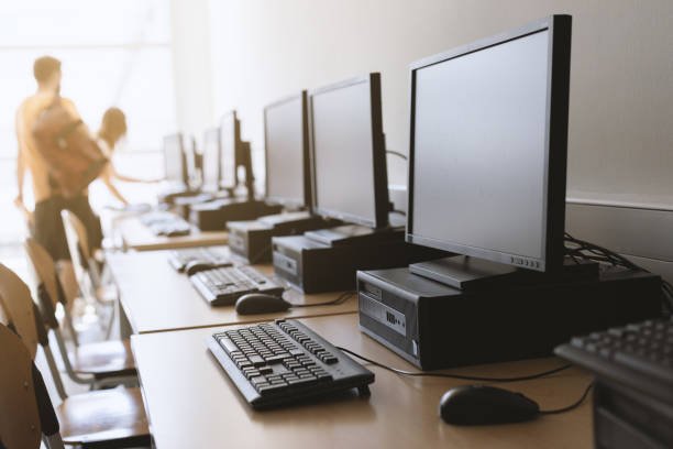 row of desktop computers in classroom setting.